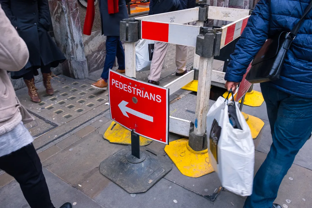 Street crossing with pedestrians sign and directional arrow