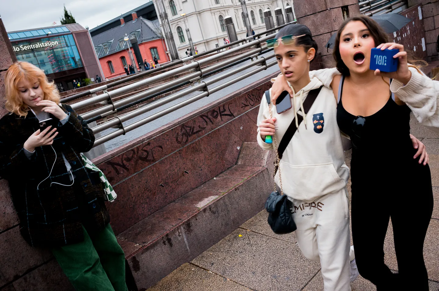 Two women walking with a speaker through the city